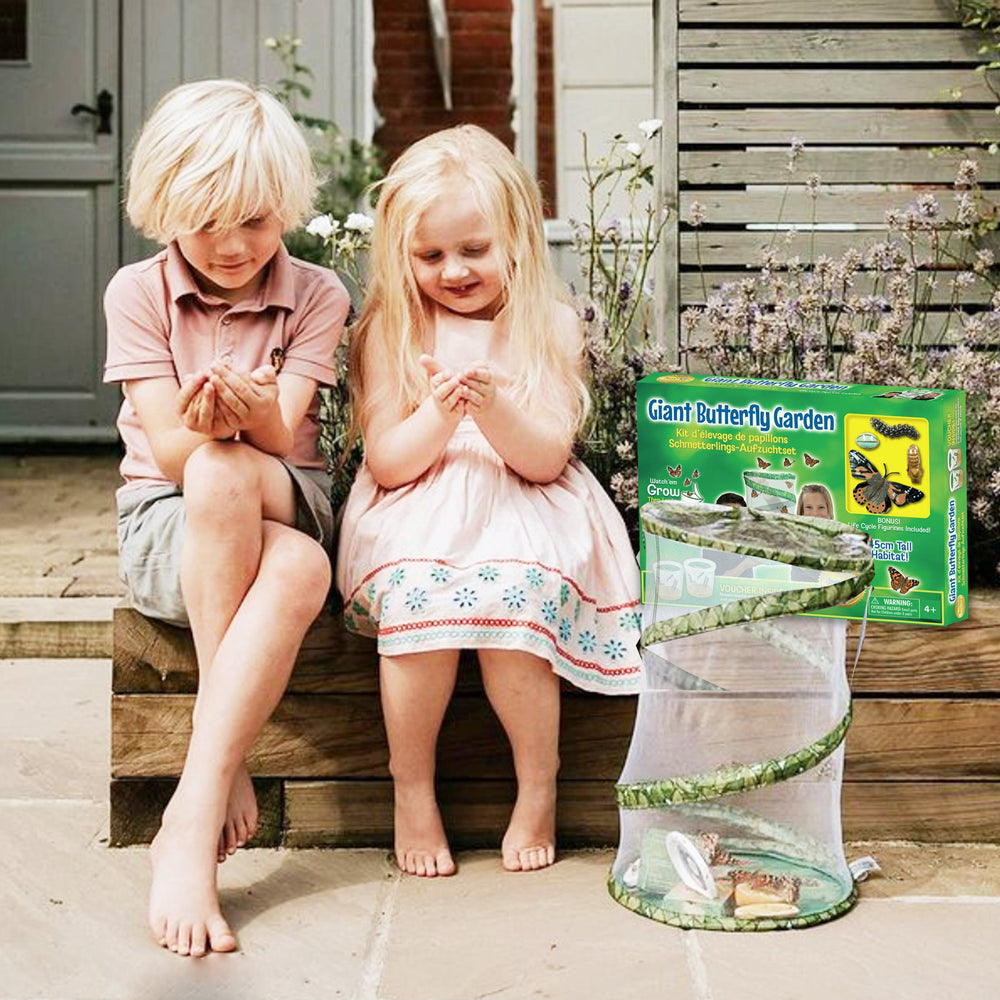 Two children sitting on steps with a Giant Butterfly Garden kit in front of them.